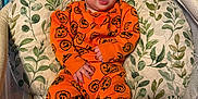 Myles joined the competition — help win amazing prizes! baby, child, infant, orange_clothing, pumpkin_pattern, boots, baby_seat, cushion, leaf_pattern, indoor, happy, smiling, face, hands, feet, person, cute, comfortable, surprised, expression