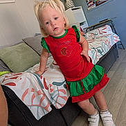 Olivia a rejoint le concours — aidez-le/la à gagner de superbes lots ! toddler, child, indoor, couch, dress, white_shoes, blonde_hair, family_photos, living_room, flooring, lamp, pillow, blanket, furniture, person, standing, curious, casual, home, portrait