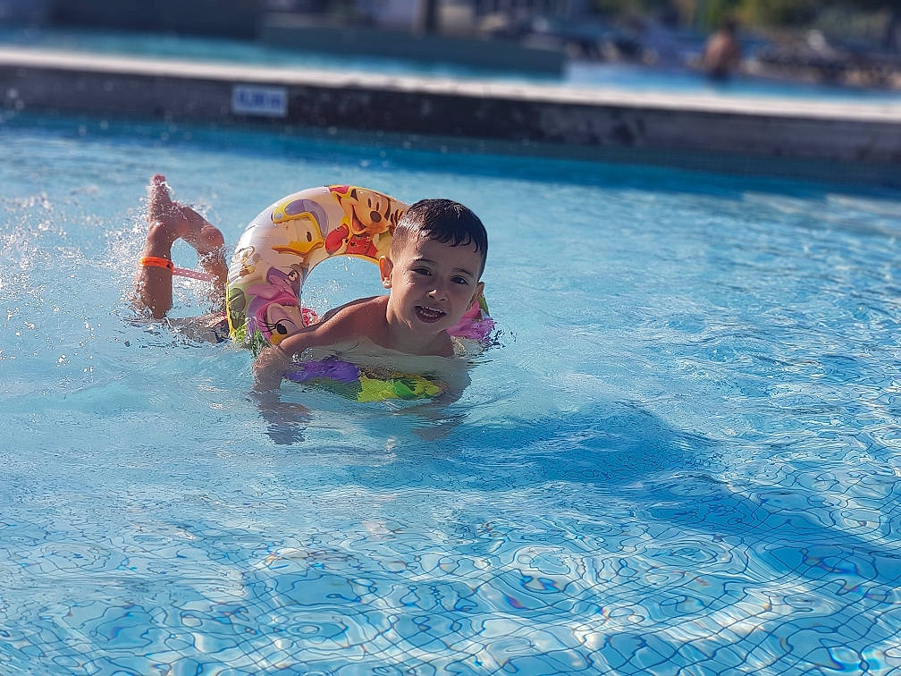 Kaïs participe au concours pour gagner de l'argent avec cette photo : child, fun, games, individual_sports, leisure, leisure_centre, nonbuilding_structure, park, person, recreation, sky, summer, swimmer, swimming, swimming_pool, vacation, water, water_park, wave