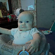 Remington joined the competition — help win amazing prizes! baby, infant, baby_seat, onesie, toy, plush_toy, ring_toy, face, eyes, hand, arm, indoor, bedroom, dresser, mirror, picture_frame, patterned_wallpaper, fan, soda_can, blanket