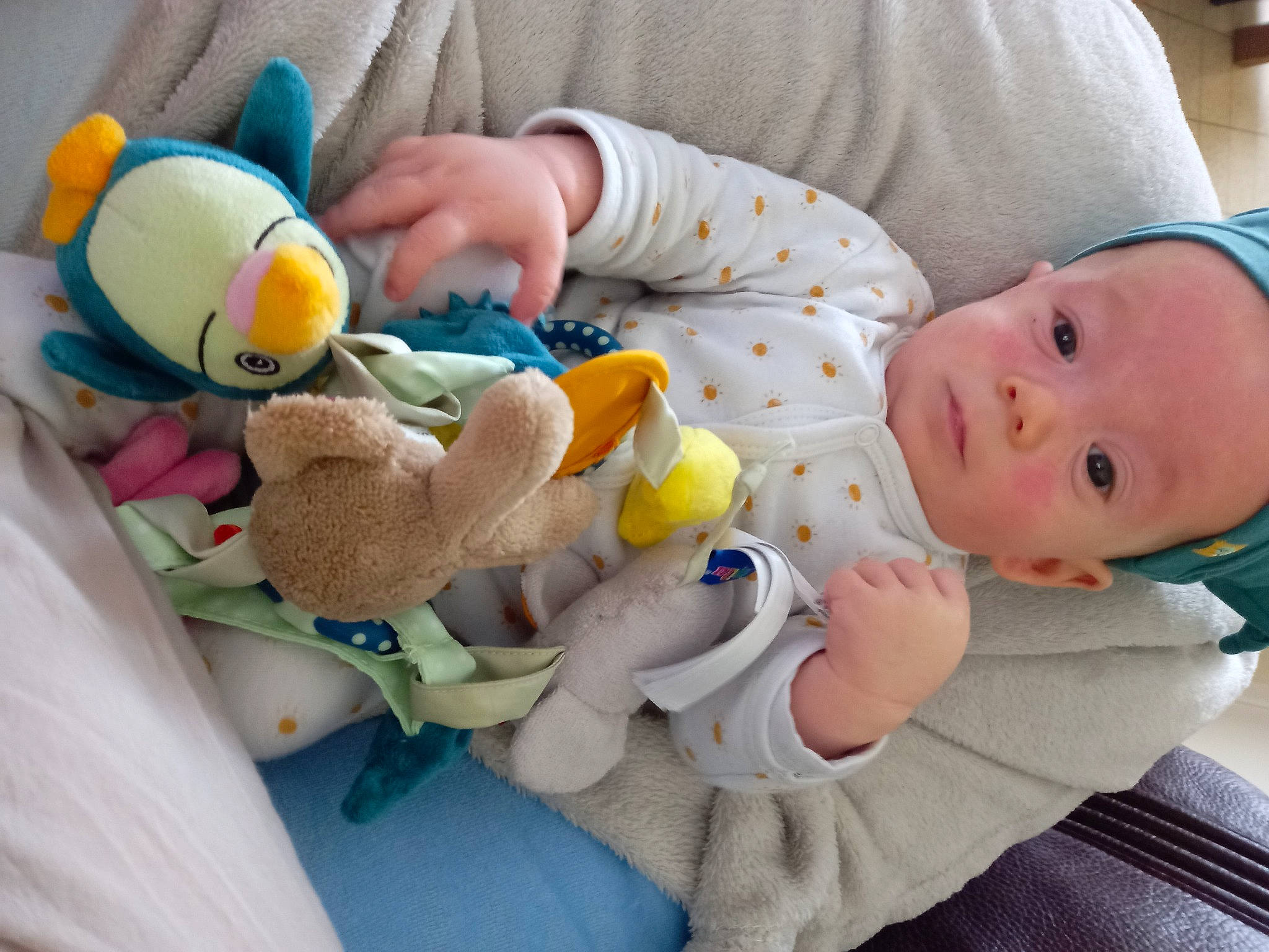 Anthony participe au concours pour gagner de l'argent avec cette photo : arm, baby, baby_products, baby_toddler_clothing, blue, cheek, child, comfort, finger, hand, human_body, mammal, person, product, skin, textile, toddler, toy, vertebrate, white