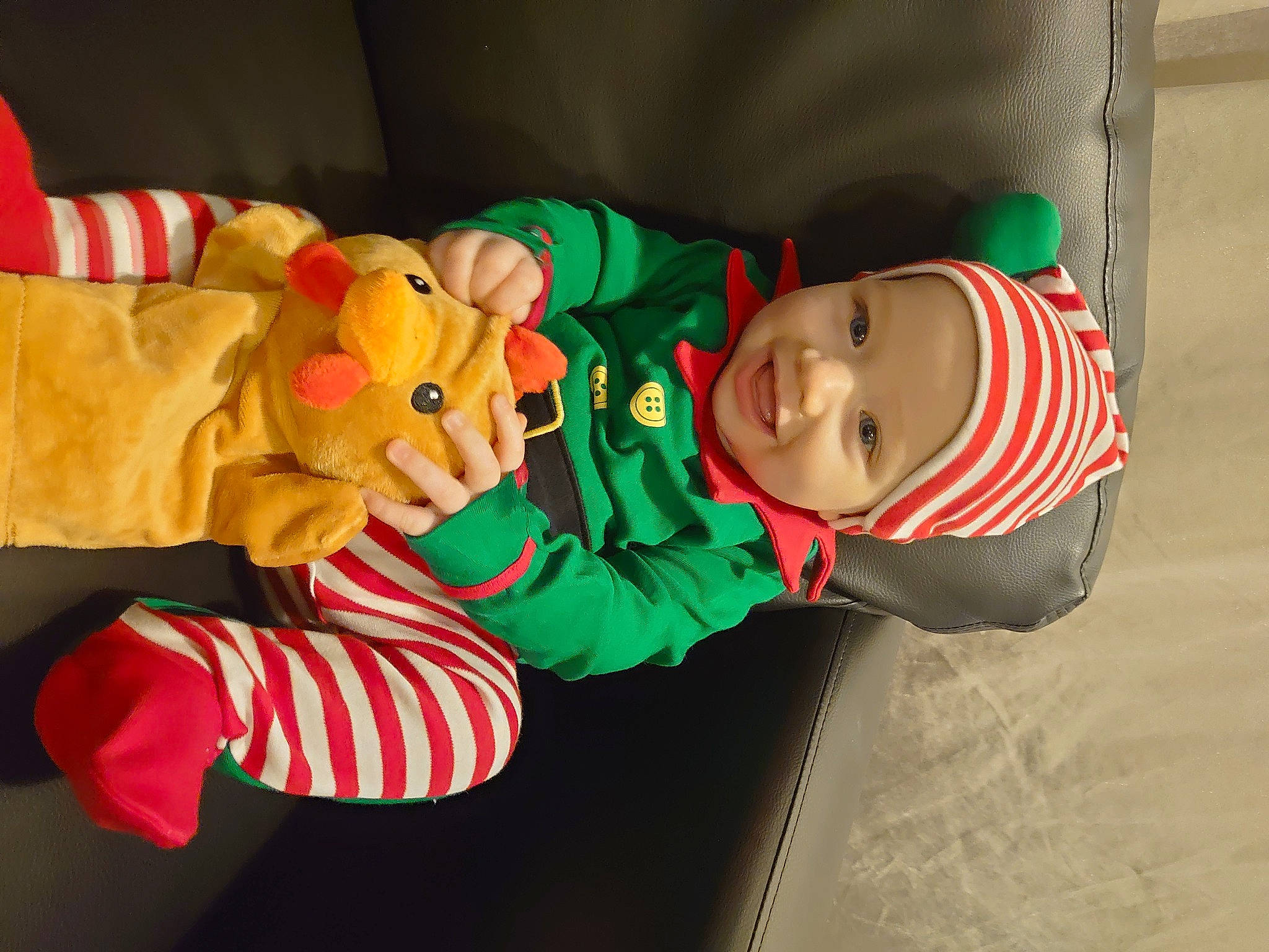 Mckenzie is registered to the contest to win money with this photo: baby, baby_toddler_clothing, carmine, child, christmas, christmas_eve, comfort, costume, event, fictional_character, flooring, fun, hat, headwear, holiday, person, room, toddler, tree