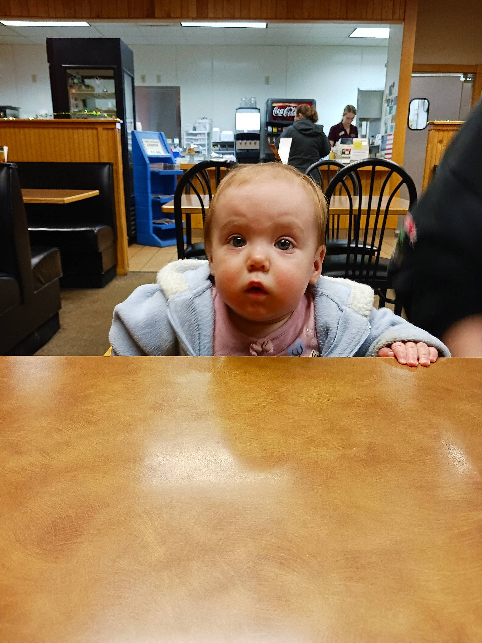 Athena is registered to the contest to win money with this photo: baby, blurred, chair, child, comfort, desk, floor, flooring, fun, furniture, hardwood, laminate_flooring, person, room, sitting, t_shirt, table, television, toddler, under_exposed