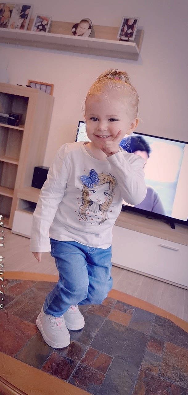 Lyana participe au concours pour gagner de l'argent avec cette photo : active_pants, baby_toddler_clothing, blond, bookcase, cabinetry, child_model, denim, floor, flooring, hair_accessory, headband, headpiece, joy, long_sleeved_t_shirt, person, shelf, shelving, sleeve, sock, sweatpant