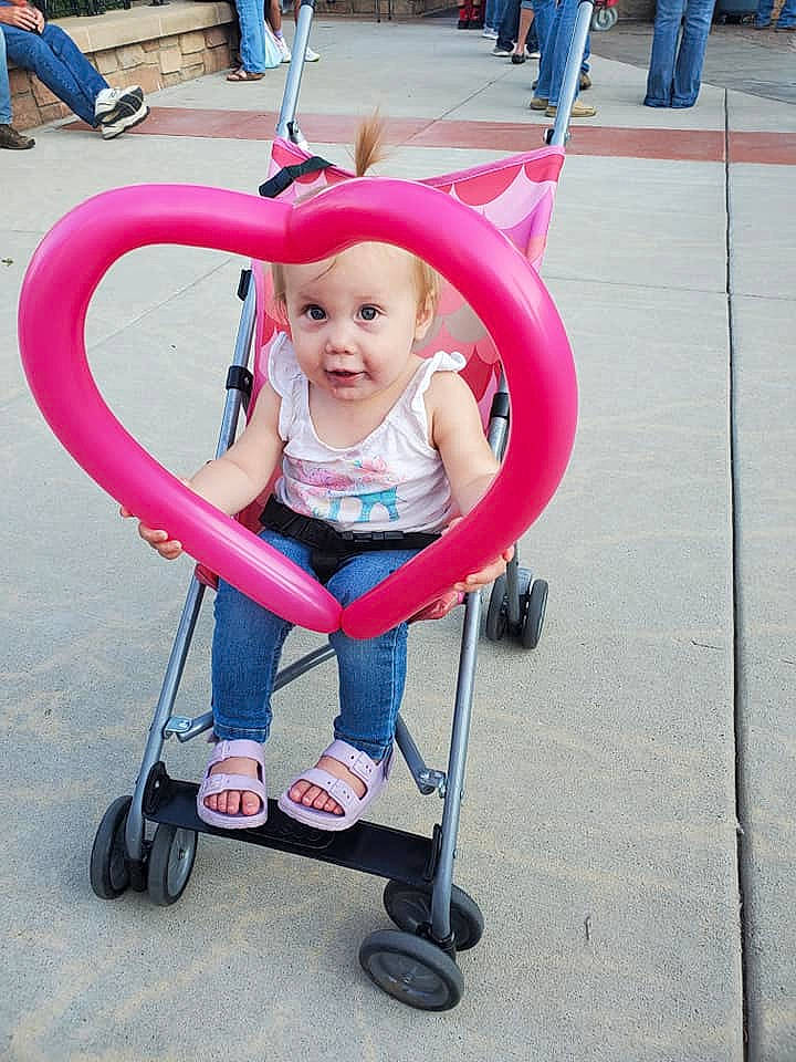 Adalynn is registered to the contest to win money with this photo: baby, baby_carriage, baby_products, baby_toddler_clothing, chair, child, comfort, event, eye, fun, happy, headwear, leisure, magenta, person, pink, recreation, sitting, smile, tire