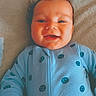 Kane is registered to the contest to win money with this photo: baby, baby_garment, blanket, blue_clothing, child, closeup, cute, expression, face, hand, happy, indoors, infant, lying_down, onesie, portrait, smiley_faces, smiling, soft_texture, young_child