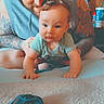 Kane is registered to the contest to win money with this photo: adult, baby, candid, cap, carpet, casual_clothing, child, controller, crawling, family, furniture, game_controller, hoodie, indoor, man, person, portrait, smile, tattoos, wood_paneling