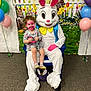 backdrop, balloons, basket, carpet, celebration, chair, child, costume, easter_bunny, face_paint, flowers, grass, holiday, indoor, party, portrait, smile, sneakers, socks, toddler