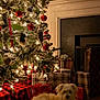 dog, christmas_tree, holiday, lights, ornaments, gifts, plaid, fireplace, wooden_floor, decorations, festive, cozy, indoors, pet, winter, warm_lighting, relaxing, holiday_season, celebration, home