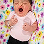 newborn, baby, yawn, pink_onesie, black_pants, floral_blanket, infant, cute, sleepy, portrait, lying_down, hand, face, closeup, soft, colorful, young, person, indoors, baby_wear
