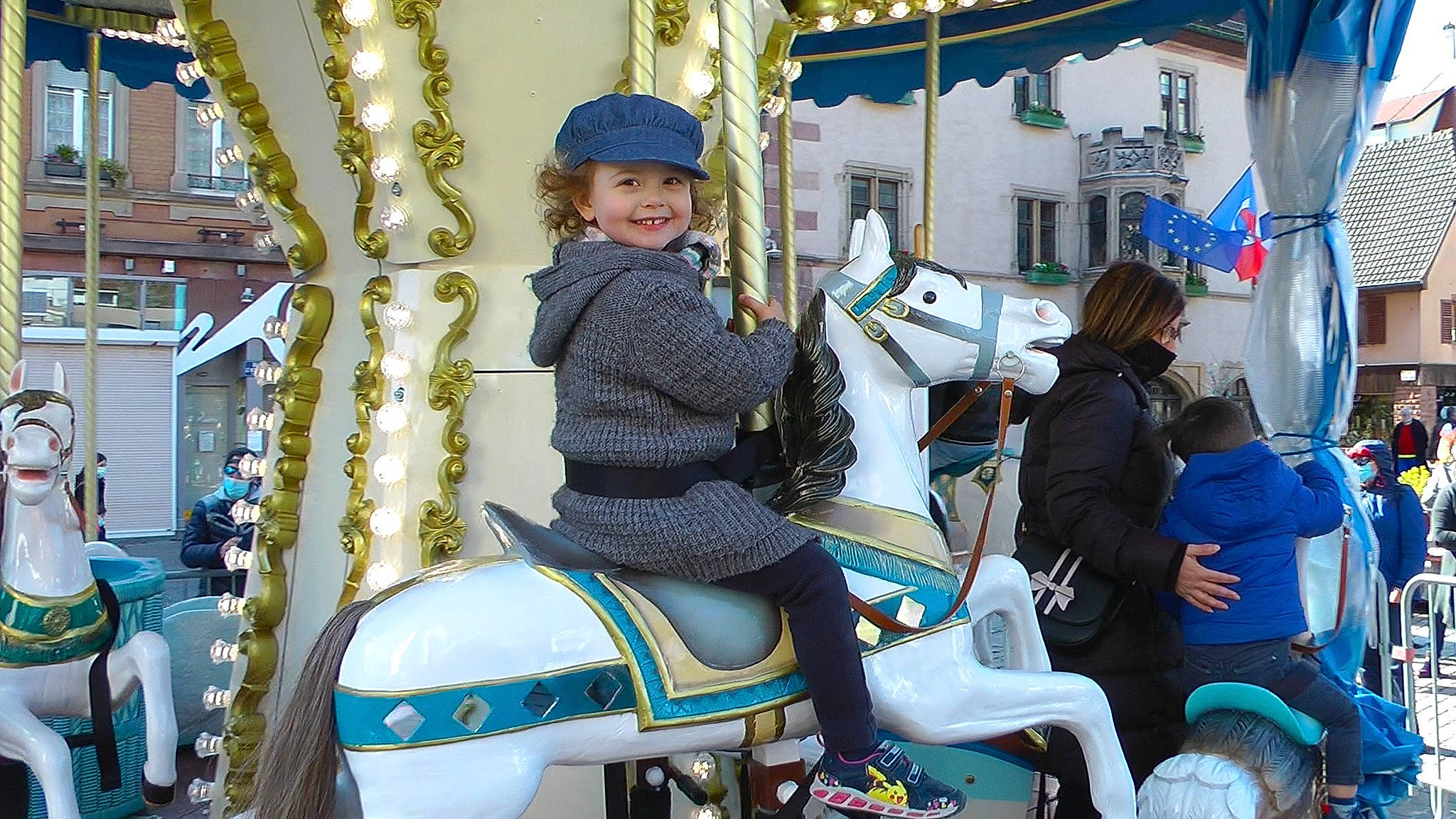 Jade participe au concours pour gagner de l'argent avec cette photo : amusement_ride, blue, bridle, carousel, carriage, event, fun, headgear, headwear, horse, horse_tack, jacket, joy, leisure, motor_vehicle, nonbuilding_structure, person, personal_protective_equipment, playground, recreation