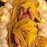 baby, towel, yellow, clouds, lights, moon, stars, wooden_plaque, sleeping, cute, newborn, soft, cozy, nursery, child, wrapped, adorable, warm_lighting, decor, face_hidden