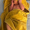 Ahmed is registered to the contest to win money with this photo: baby, child, towel, yellow, wrapped, cute, skin, hand, feet, face, hood, soft, lying_down, indoors, blanket, infant, newborn, playful, covering_face, cozy