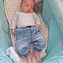 baby, sleeping, bassinet, plush_toy, denim_pants, white_top, blanket, infant, cozy, child, footwearless, patterned_sheet, resting, indoor, cute, peaceful, newborn, soft_toy, fabric, home