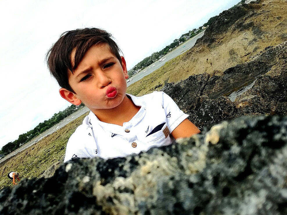 Esdras a rejoint le concours — aidez-le/la à gagner de superbes lots ! beauty, black_hair, happy, person, photo_shoot, photography, rock, sitting, smile, t_shirt