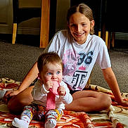 Diana joined the competition — help win amazing prizes! child, baby, toddler, girl, smiling, indoor, carpet, blanket, clothing, sitting, blue_eyes, long_hair, playing, cute, happy, family, floor, patterned_pants, white_socks, casual