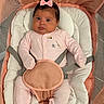 adorable, baby, baby_girl, baby_seat, bow, child, comfortable, cushion, cute, expression, indoors, infant, looking_at_camera, mesh, newborn, pink_onesie, portrait, seated, soft_lighting, straps