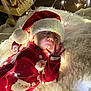 Aleksandra is registered to the contest to win money with this photo: baby, infant, santa_hat, christmas_outfit, fairy_lights, holiday, festive, red_clothing, white_rug, cozy, cute, child, indoors, celebration, sparkle, glow, hand, face, smile, seasonal