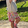 bench, casual_clothing, child, cute, daytime, grass, hair_bun, happy, motion, outdoor, pavement, playful, pointing, red_hair, shorts, sneakers, summer, sunlight, toddler, white_shirt
