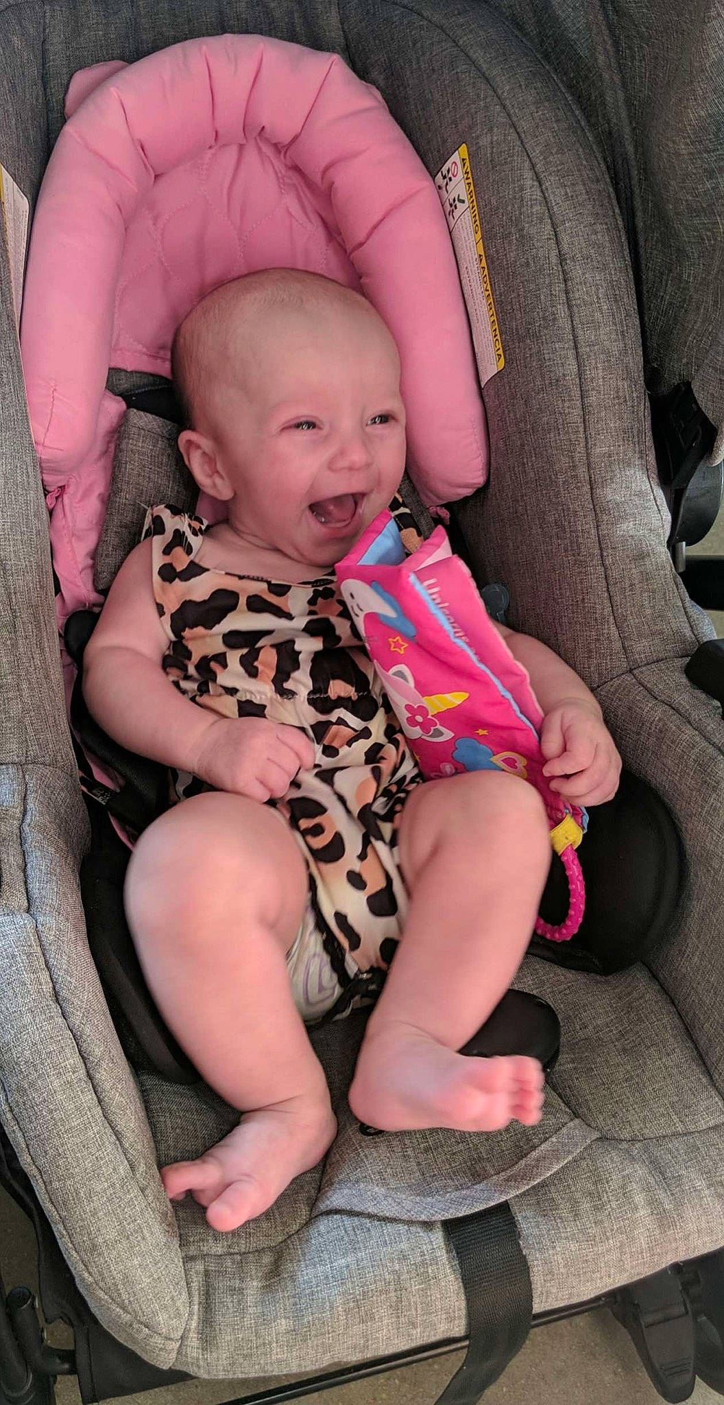 Madilynn is registered to the contest to win money with this photo: baby, baby_toddler_clothing, car_seat, cheek, comfort, finger, happy, human_body, joint, knee, lap, leg, mouth, neck, person, pink, skin, smile, sock, thigh