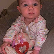Bristol joined the competition — help win amazing prizes! baby, child, pajamas, plush_toy, teether, heart_shape, drool, face, hand, chair, indoor, cute, infant, person, seated, soft_furniture, expression, closeup, young_child, sleepwear