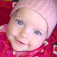 Chelsea is registered to the contest to win money with this photo: baby, child, blue_eyes, pink_hat, pom_pom, knit_hat, jacket, heart_pattern, smile, close_up, face, cute, warm_clothing, infant, portrait, cozy, colorful, indoor, happy, young