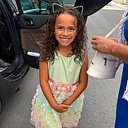 Sïana a rejoint le concours — aidez-le/la à gagner de superbes lots ! child, girl, smile, curly_hair, dress, pastel_colors, floral, headband, cat_ears, sandals, street, car, open_car_door, sidewalk, person, happy, outdoor, fashion, accessory, portrait