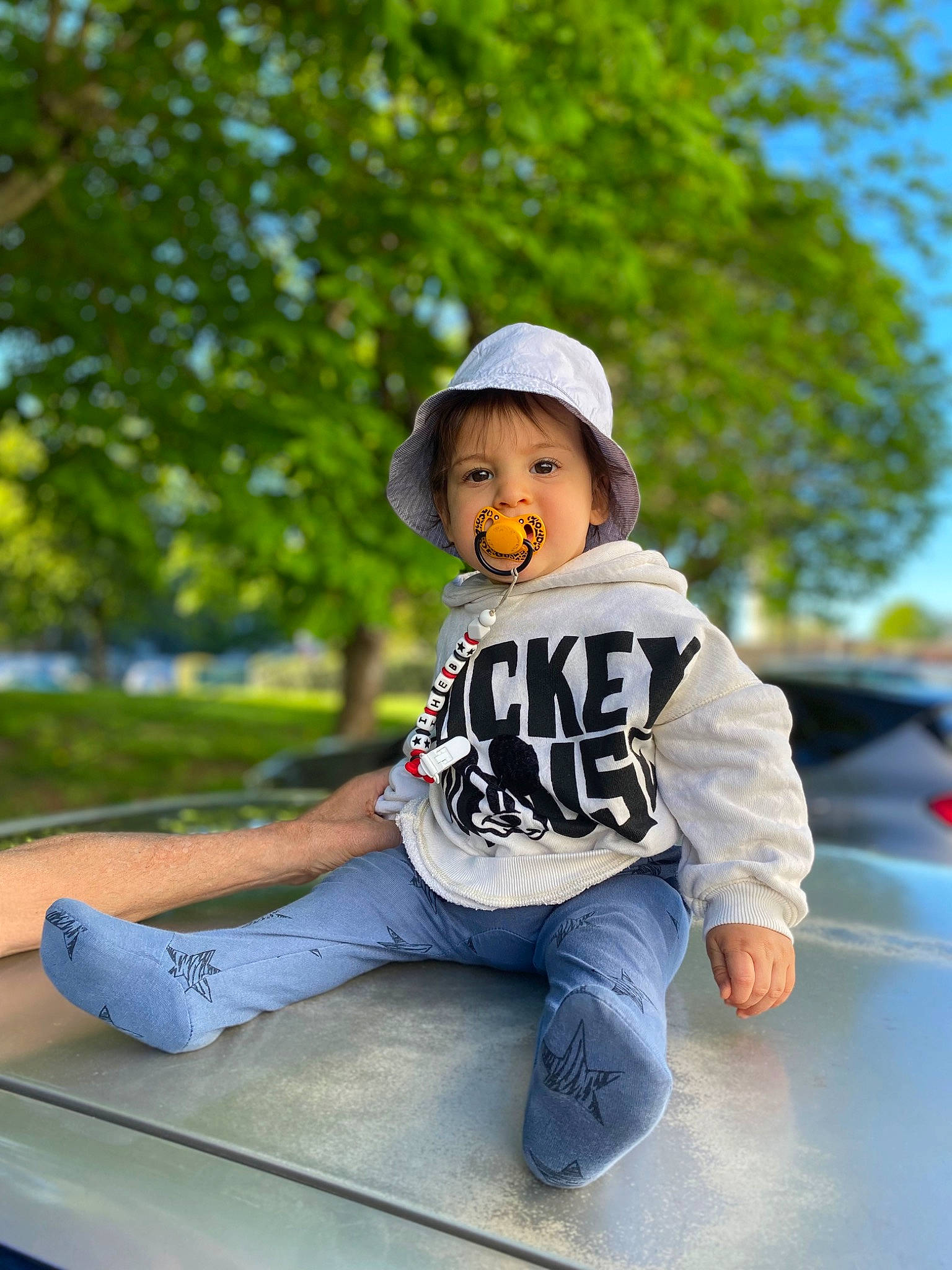 Iheb participe au concours pour gagner de l'argent avec cette photo : baby_toddler_clothing, cap, flash_photography, fun, grass, happy, hat, headgear, headwear, leisure, person, personal_protective_equipment, recreation, shoe, sitting, sleeve, sneakers, street_fashion, sun_hat, t_shirt