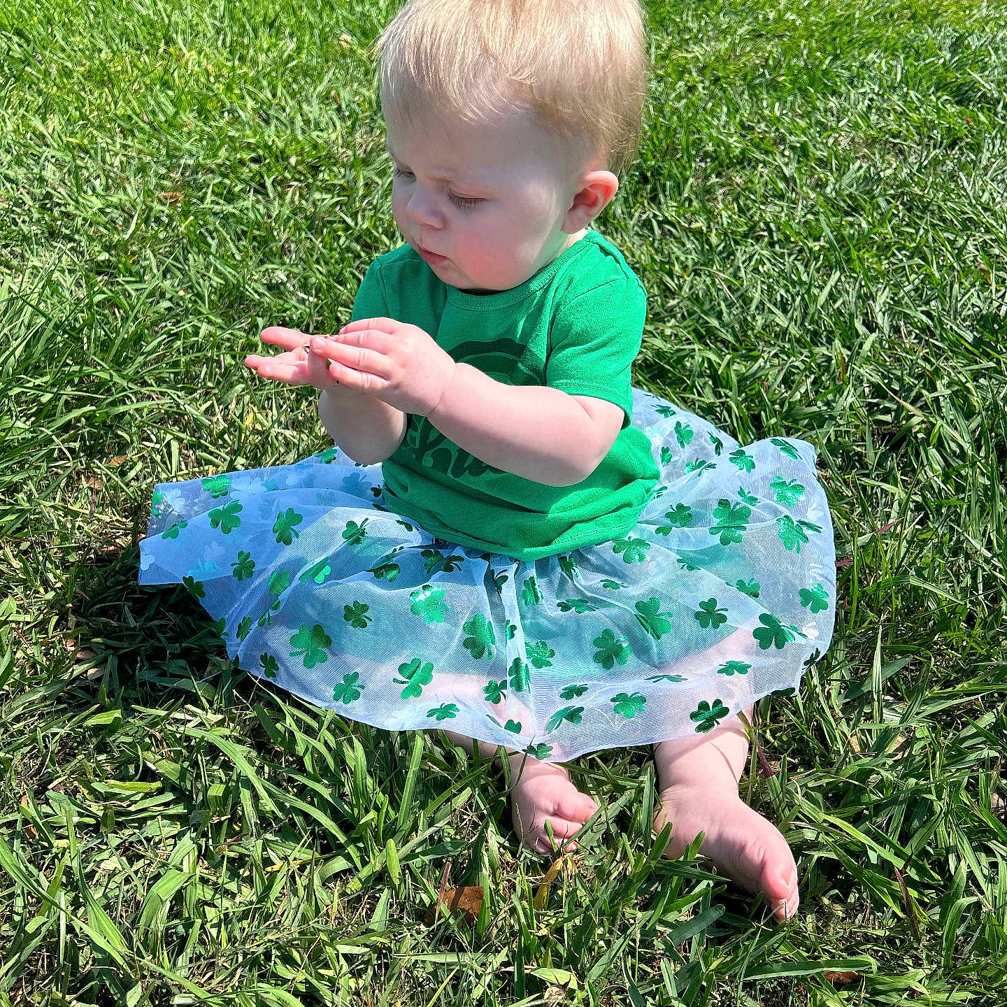 Faye is registered to the contest to win money with this photo: baby, bodypart, clothing, dress, face, field, finger, grass, grassland, hand, head, lawn, nature, outdoors, person, photography, plant, portrait, sitting, skirt