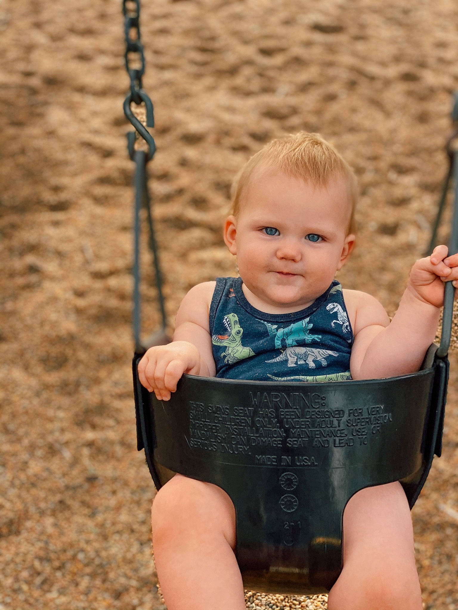 Kooper is registered to the contest to win money with this photo: baby, baby_toddler_clothing, cheek, chin, eye, face, fun, grass, hair, hand, happy, head, human_body, leisure, people_in_nature, person, playground, skin, smile, swing