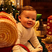 Renley joined the competition — help win amazing prizes! baby, carpet, child, christmas, cozy, cute, decorations, face, festive, gift, happy, holiday, holiday_lights, indoors, knitwear, present, sitting, smiling, toy, warm_lighting