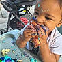 toddler, child, cake, frosting, messy, high_chair, food, eating, hands, face, outdoor, stroller, colorful, birthday, celebration, happy, young_child, party, sweet, fun