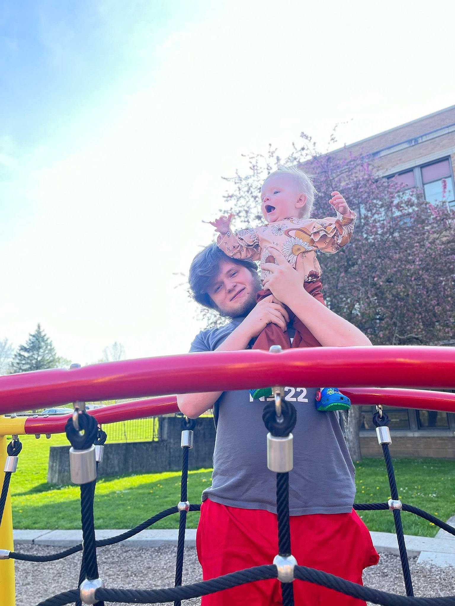 Scarlett is registered to the contest to win money with this photo: city, cloud, electric_blue, fun, grass, hat, human_leg, joy, knee, leisure, outdoor_play_equipment, person, playground, playground_slide, public_event, recreation, shorts, sitting, sky, t_shirt