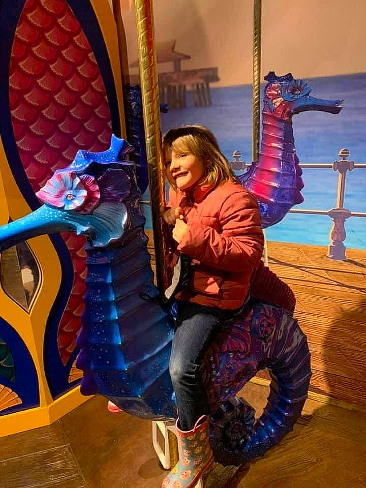 Kylee Mae is registered to the contest to win money with this photo: amusement_park, beauty, boot, child, city, electric_blue, event, fun, happy, human_body, leisure, magenta, nonbuilding_structure, outdoor_play_equipment, person, purple, recreation, sitting, smile, snapshot