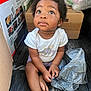 toddler, child, sitting, curious, plastic_bag, cardboard_box, floor, clothing, shorts, indoor, baby, person, cute, expression, earring, black_hair, casual, looking_up, small_hands, barefoot