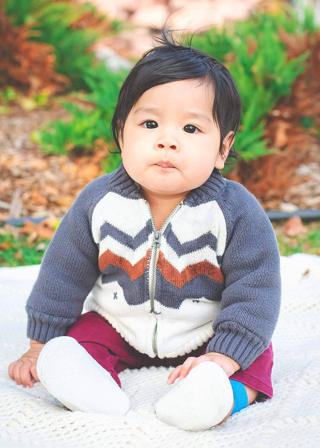 Dexter joined the competition — help win amazing prizes! baby, baby_toddler_clothing, black_hair, cheek, child, doll, facial_expression, grass, happy, lip, outerwear, people, people_in_nature, person, plant, sitting, skin, sleeve, toddler, toy