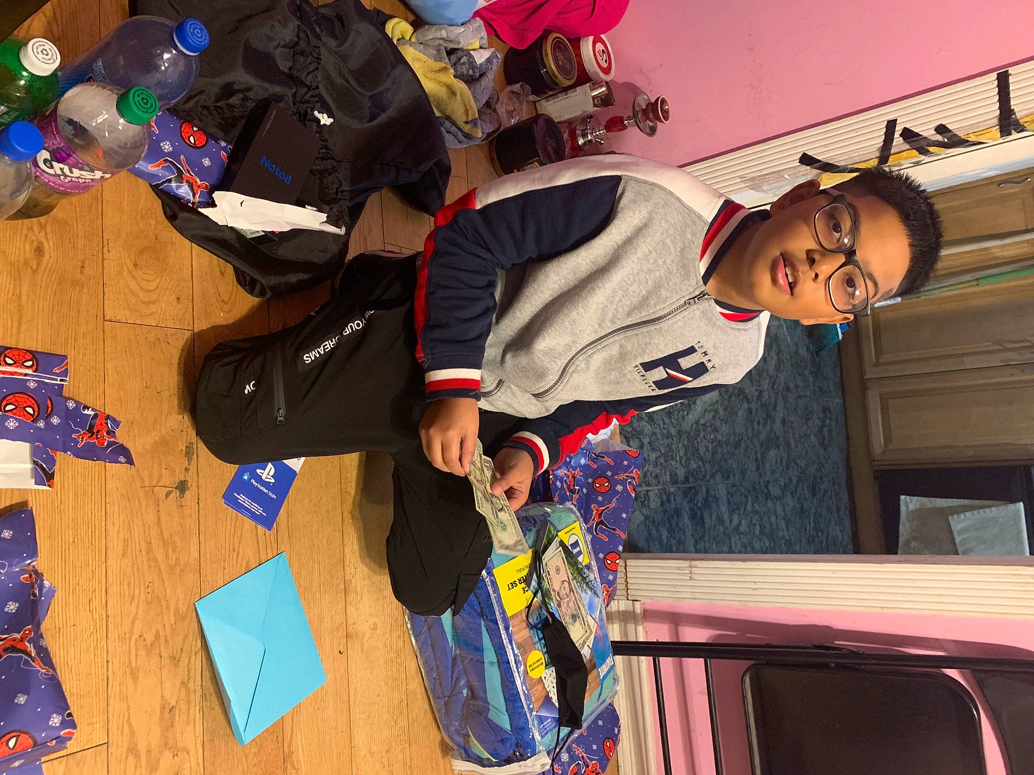 Aiden is registered to the contest to win money with this photo: bag, carmine, child, eyewear, fun, happy, luggage_and_bags, person, play, room, sleeve, smile, sportswear, t_shirt, toddler, world