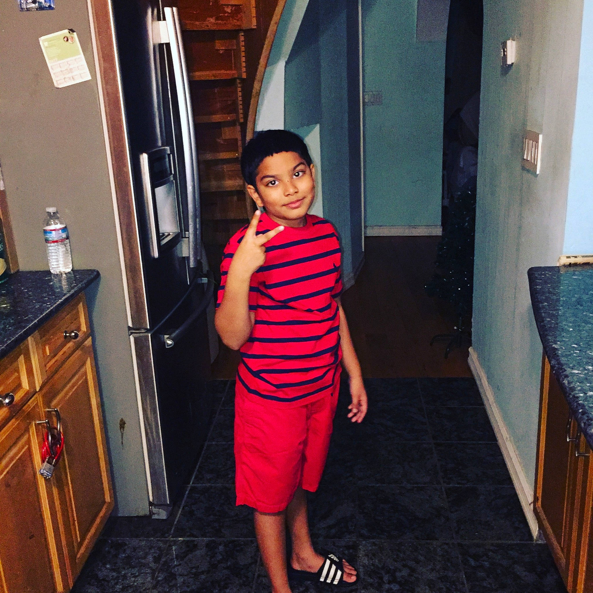 Aiden is registered to the contest to win money with this photo: cabinetry, chest_of_drawers, door, drawer, electric_blue, eyewear, fashion_design, floor, flooring, fun, home_door, house, human_leg, joy, leisure, magenta, person, room, standing, t_shirt