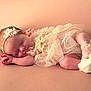 newborn, baby, sleeping, infant, headband, lace, dress, peach, soft, closeup, portrait, cute, peaceful, resting, small, delicate, footwear, indoors, skin, adorable
