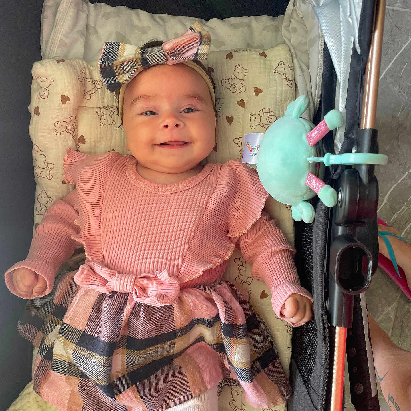 Layana participe au concours pour gagner de l'argent avec cette photo : baby, child, cloth, cushion, cute, footwear, hand, happy, headband, indoor, infant, person, pink_dress, plaid, portrait, smiling, stroller, teddy_bear_pattern, toy, white_tights