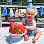 baby, smiling, party_hat, watermelon, cake, outdoor, blanket, denim_overalls, celebration, half_birthday, tassel_garland, banner, sunlight, grass, foot, hands, face, happy, summer, table