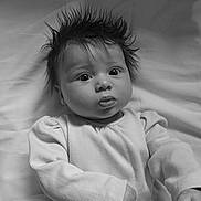 Ophelia is registered to the contest to win money with this photo: baby, infant, child, black_and_white, portrait, wide_eyes, spiky_hair, long_sleeve_shirt, ribbed_clothing, lying_down, soft_background, fabric, curious_expression, monochrome, close_up, person, cute, indoors, young, head_shot
