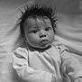 baby, infant, child, black_and_white, portrait, wide_eyes, spiky_hair, long_sleeve_shirt, ribbed_clothing, lying_down, soft_background, fabric, curious_expression, monochrome, close_up, person, cute, indoors, young, head_shot