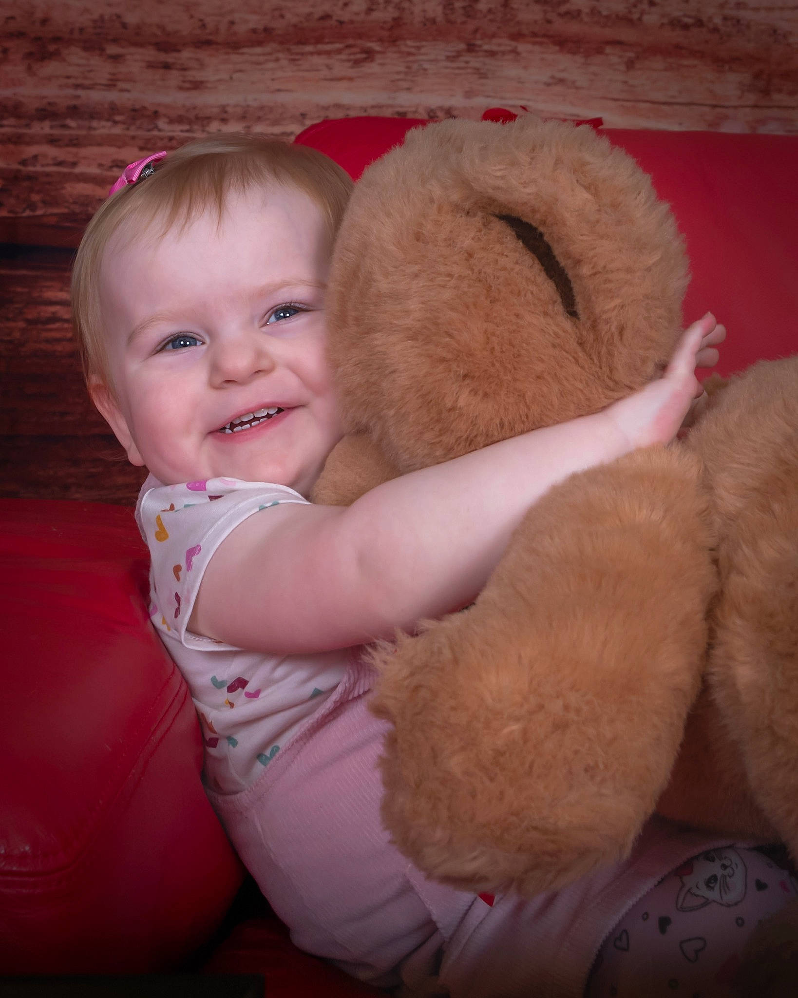 Jemma is registered to the contest to win money with this photo: arm, baby, baby_toddler_clothing, child, comfort, fawn, flash_photography, foot, fun, fur, gesture, happy, joy, mammal, person, pink, skin, smile, stuffed_toy, teddy_bear