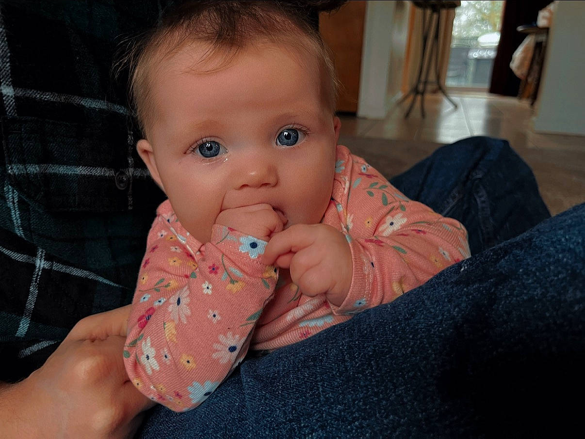 Tessa is registered to the contest to win money with this photo: baby, baby_toddler_clothing, chair, cheek, child, chin, ear, eyelash, finger, hand, head, iris, lip, mouth, nail, nose, person, skin, sleeve, thumb