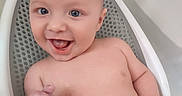 Giovanni is registered to the contest to win money with this photo: baby, infant, child, smiling, laughing, bathtub, bath_seat, bathroom, wet, bare_chested, portrait, face, eyes, open_mouth, happy, sitting, indoor, water, clean, playful