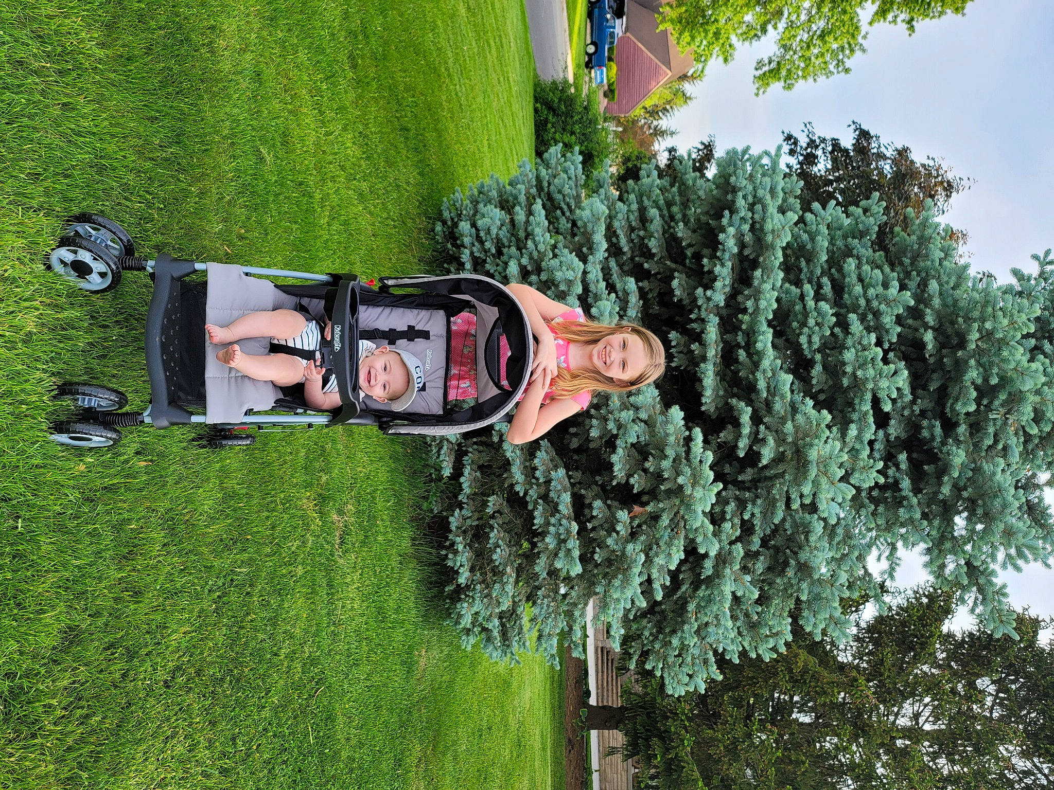 Monica is registered to the contest to win money with this photo: automotive_exterior, car, family_car, fun, garden, grass, green, headwear, joy, landscape, lawn, leisure, motor_vehicle, person, plant, pole, recreation, shrub, sky, tree