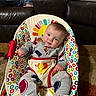 baby, child, pajamas, baby_chair, colorful, patterned, smiling, indoor, carpet, couch, leather, person, jeans, foot, toy, sun_design, cozy, home, furniture, portrait