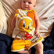 Abby joined the competition — help win amazing prizes! baby, child, infant, toddler, person, clothing, yellow_shorts, looney_tunes, tweety_bird, blanket, fabric, couch, relaxing, indoors, cute, portrait, smiling, skin, head, face