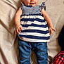 Abby joined the competition — help win amazing prizes! baby, child, smiling, striped_clothing, blue_pants, lying_down, happy, infant, cute, person, fabric, denim, socks, background, indoors, face, skin, small_hands, casual_clothing, portrait